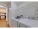 In-unit laundry area with shelving and a full-size washer and dryer at 5500 Metrowest Blvd # 203, Orlando, FL 32811