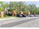 Exterior shot of the condo buildings showing a parking area, lush green foliage, and landscaping at 5500 Metrowest Blvd # 203, Orlando, FL 32811