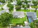 Aerial view of home with a well-maintained lawn, screened pool, and privacy fencing at 609 Langholm Dr, Winter Park, FL 32789
