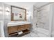 Elegant bathroom featuring a double vanity, marble tile, soaking tub, and modern fixtures at 609 Langholm Dr, Winter Park, FL 32789
