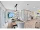 The dining room has a long wooden table with tufted chairs and views to the kitchen and backyard at 609 Langholm Dr, Winter Park, FL 32789