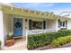 Close-up of a cozy front porch with a light blue door, decorative wreath, and charming landscaping at 609 Langholm Dr, Winter Park, FL 32789