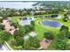 Scenic aerial view of a community park with ponds, playground, basketball court, and green spaces at 6321 Clearmeadow Ct, Windermere, FL 34786
