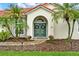 Inviting front entrance with a teal double door, arched entryway and manicured landscaping at 6321 Clearmeadow Ct, Windermere, FL 34786