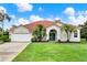 Charming single-story home featuring a red tile roof, attached garage and a beautifully manicured lawn at 6321 Clearmeadow Ct, Windermere, FL 34786