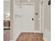Welcoming hallway with wood floors and white trim features hooks, a door, and easy access to other rooms at 6321 Clearmeadow Ct, Windermere, FL 34786