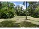 Beautiful backyard featuring green grass, mature trees and a fire pit area at 637 15Th St, Debary, FL 32713