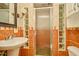 Bathroom featuring a pedestal sink, glass enclosed shower, and unique tile design at 637 15Th St, Debary, FL 32713