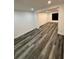 Spacious finished basement with gray wood-look vinyl floors and recessed lighting at 6849 Palomino Dr, Lakeland, FL 33811