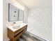 Modern bathroom with sleek vanity, stylish mirror, and walk-in shower with white marble tile at 6849 Palomino Dr, Lakeland, FL 33811
