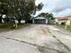 Charming home featuring a gray exterior, a spacious driveway, and mature trees at 6849 Palomino Dr, Lakeland, FL 33811