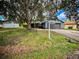 Charming single-Gathering home featuring a well-maintained lawn, mature trees, and a two-car garage at 6849 Palomino Dr, Lakeland, FL 33811