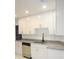 Bright kitchen featuring white cabinets, granite countertops, stainless steel appliances, and new flooring at 6849 Palomino Dr, Lakeland, FL 33811