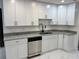 Bright kitchen featuring white cabinets, granite countertops, stainless steel appliances, and new flooring at 6849 Palomino Dr, Lakeland, FL 33811