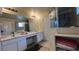 Bright bathroom featuring a double vanity, large mirror, and glass-enclosed shower at 720 Las Fuentes Dr, Kissimmee, FL 34746