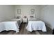 Bedroom featuring two twin beds, gray and white decor, wood-look floors and butterfly art at 720 Las Fuentes Dr, Kissimmee, FL 34746