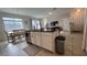 Kitchen island with stainless sink, black counter, white cabinets and seating overlooking the living room at 720 Las Fuentes Dr, Kissimmee, FL 34746