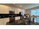 Modern kitchen with stainless steel appliances, dark backsplash and countertop, and white cabinets at 720 Las Fuentes Dr, Kissimmee, FL 34746