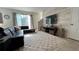 Spacious living room with sliding glass doors, modern decor, neutral walls, and wall-mounted TV at 720 Las Fuentes Dr, Kissimmee, FL 34746