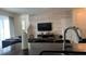 Living room area with modern decor, a large television, and faux brick wall at 720 Las Fuentes Dr, Kissimmee, FL 34746