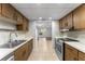 Galley kitchen with stainless steel appliances, wood cabinets, and tiled floor at 818 Park Lake Cir # 10, Maitland, FL 32751