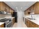 Galley kitchen featuring stainless steel appliances and wooden cabinets at 818 Park Lake Cir # 10, Maitland, FL 32751