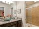 Well-lit bathroom featuring double sinks with granite counters and a glass-enclosed shower at 8801 Corcovado Dr, Kissimmee, FL 34747