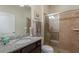 Cozy bathroom featuring tiled shower with glass door and vanity with granite countertop and decorative mirror at 8801 Corcovado Dr, Kissimmee, FL 34747