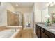 Inviting bathroom features a soaking tub, a walk-in shower, and a dual sink vanity with granite countertop at 8801 Corcovado Dr, Kissimmee, FL 34747