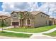 Well-manicured lawn complements this home's stone facade and neutral siding, set in a tranquil neighborhood at 8801 Corcovado Dr, Kissimmee, FL 34747