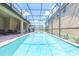 Backyard view of a stunning pool with an enclosure and brick-paved deck at 8801 Corcovado Dr, Kissimmee, FL 34747