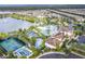 Aerial view of the community pool with a lake, slides, lounge chairs, trees, and a basketball court at 8801 Macapa Dr, Kissimmee, FL 34747