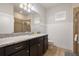 Bathroom features granite countertops, dark cabinets, a large mirror, and a glass enclosed shower at 8801 Macapa Dr, Kissimmee, FL 34747