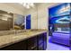 Bathroom with a granite countertop, black cabinetry and a glass enclosed shower at 8801 Macapa Dr, Kissimmee, FL 34747