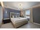Primary bedroom with a luxurious bed, decorative lighting, and relaxing blue accent wall at 8801 Macapa Dr, Kissimmee, FL 34747