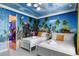Charming bedroom with bright tropical-themed mural, white twin beds and a well-lit ensuite bathroom at 8801 Macapa Dr, Kissimmee, FL 34747