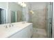 A bright, tiled bathroom with a double sink vanity and glass enclosed shower at 922 Wild Date Ln, Lake Mary, FL 32746