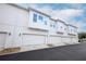 Exterior garage-level view of townhomes with white stucco and carriage-style garage doors at 922 Wild Date Ln, Lake Mary, FL 32746