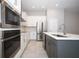 Contemporary kitchen showcasing stainless steel appliances, white cabinets, gray island, and stylish tile flooring at 922 Wild Date Ln, Lake Mary, FL 32746
