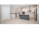 Modern kitchen with white cabinets, stainless steel appliances, gray island, and wood-look tile flooring at 922 Wild Date Ln, Lake Mary, FL 32746