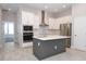 Bright kitchen featuring white cabinetry, stainless steel appliances, gray island, and wood-look tile flooring at 922 Wild Date Ln, Lake Mary, FL 32746