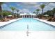 Beautiful community pool with lounge chairs, umbrellas, and a covered pavilion at 922 Wild Date Ln, Lake Mary, FL 32746