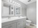 Bathroom with a double sink vanity, two mirrors, and a toilet with tile floors and light gray walls at 112 Lake Butler Ave, Haines City, FL 33844