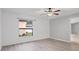 A bright bedroom with hard surface floors, a ceiling fan, light gray walls, and a window with a view at 112 Lake Butler Ave, Haines City, FL 33844