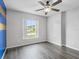 Bedroom with hard surface floors, a ceiling fan, and a window offering natural light at 112 Lake Butler Ave, Haines City, FL 33844