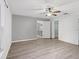 A spacious bedroom with hard surface floors, ceiling fan, walk-in closet, and white trim at 112 Lake Butler Ave, Haines City, FL 33844