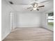 Spacious bedroom featuring wood-look flooring, a ceiling fan, a window with natural light, and white trim at 112 Lake Butler Ave, Haines City, FL 33844