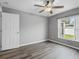 Simple bedroom featuring a ceiling fan, wood-look flooring, and window views at 112 Lake Butler Ave, Haines City, FL 33844