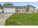 Charming single-story home with a well-maintained lawn and attached two-car garage, showcasing curb appeal at 112 Lake Butler Ave, Haines City, FL 33844