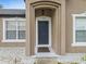 Inviting front entryway featuring a neutral color scheme, decorative rock landscaping, and a stylish exterior light fixture at 112 Lake Butler Ave, Haines City, FL 33844